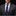 Man wearing a dark suit with a blue tie and patterned pocket square against a black background