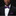 Man wearing a black suit with a red and blue striped bow tie and pocket square on a black background