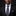 Man wearing a black suit with a blue patterned tie and pocket square on a dark background
