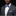 Man wearing a gray suit with a blue bow tie and pocket square on a black background