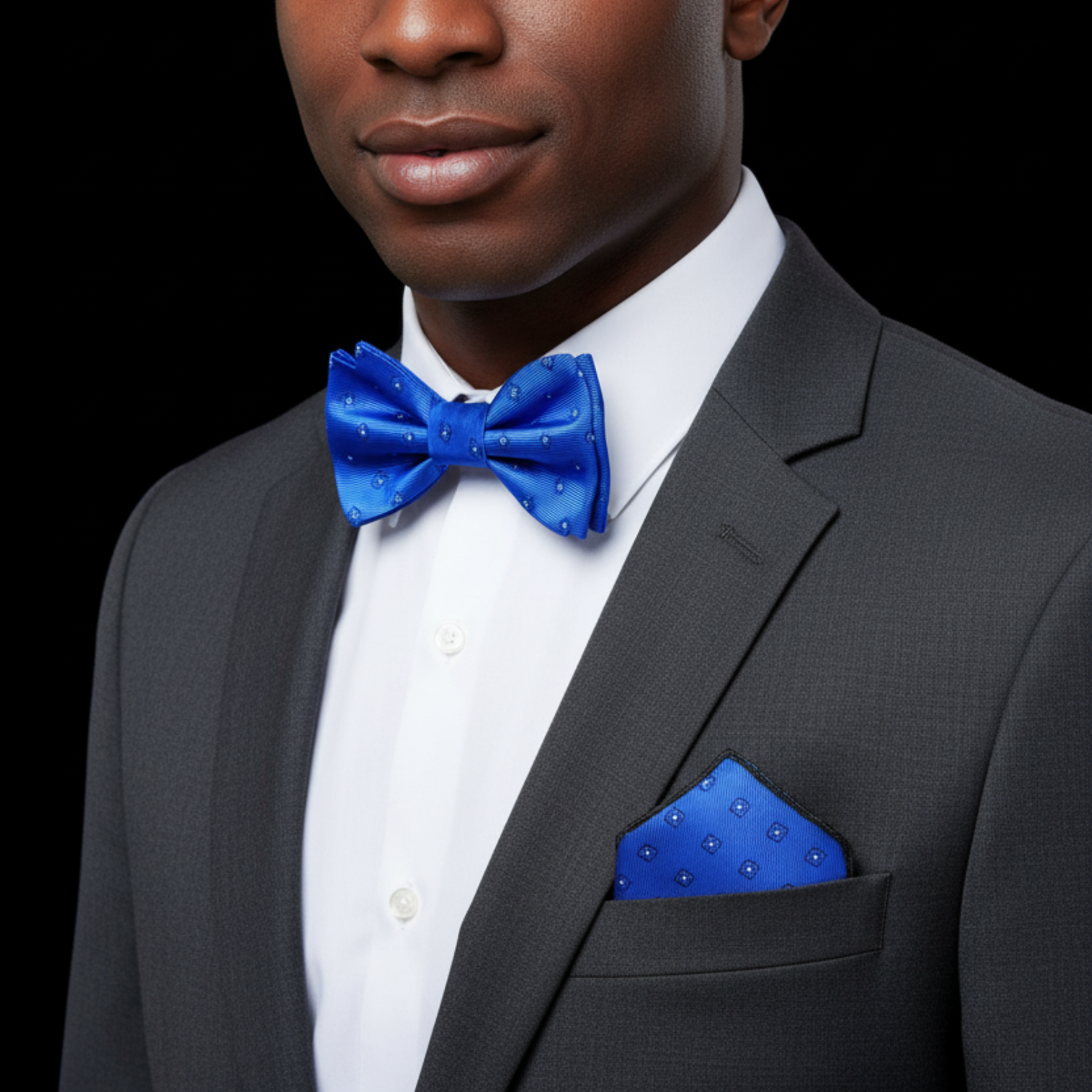 Blue bow tie and matching pocket square with floral pattern on a black background