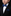 Young boy in a formal outfit with a blue bow tie and pocket square on a black background