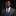 Man wearing a gray suit with a blue tie and pocket square on a black background