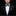 Man wearing a black suit with a checkered bow tie and pocket square on a dark background