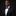 Man wearing a black suit with a blue bow tie and pocket square on a dark background