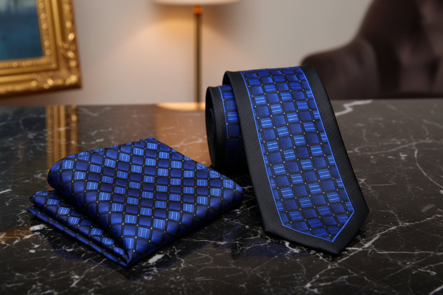Blue patterned tie and pocket square on a dark marble surface