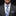 Man wearing a gray suit with a blue and gray striped tie and matching pocket square on a black background