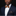Man wearing a navy suit with a patterned bow tie and pocket square on a black background