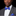 Man wearing a gray suit with a blue bow tie and matching pocket square on a black background