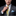 Man adjusting a yellow paisley tie with a black background