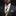 Man wearing a gray suit with a yellow and blue striped tie against a black background
