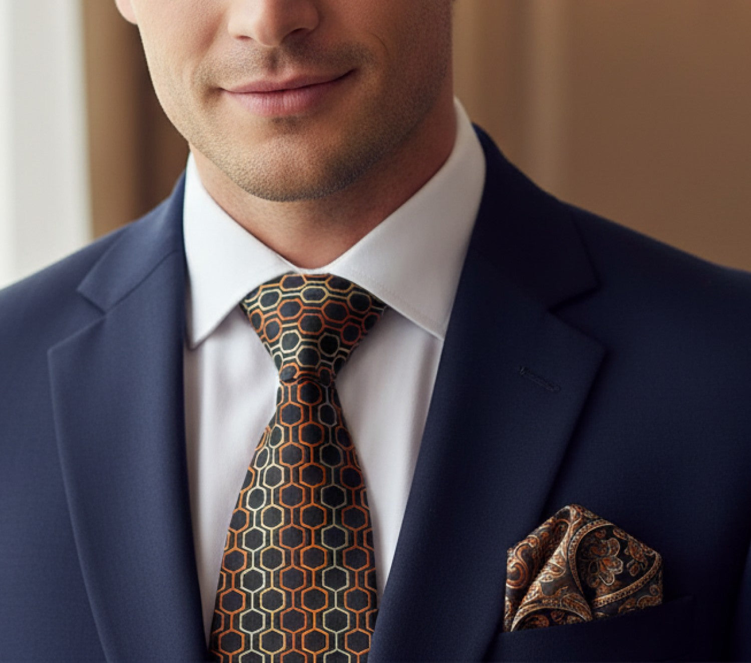 Man wearing a navy suit with a patterned tie and pocket square.
