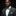 Colorful bow tie with leopard print and green accents on a white shirt, with a brown and beige pocket square below.