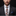 Man wearing a suit with a patterned tie against a black background