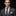 Man wearing a gray suit with a colorful floral tie and pocket square on a dark background