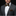 Man wearing a gray suit with a patterned bow tie and pocket square on a black background