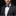 Man wearing a dark suit with a patterned bow tie and pocket square on a black background
