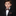 Young boy in a formal black suit with a patterned bow tie on a dark background