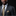 Man wearing a dark suit with a gold tie and pocket square against a black background