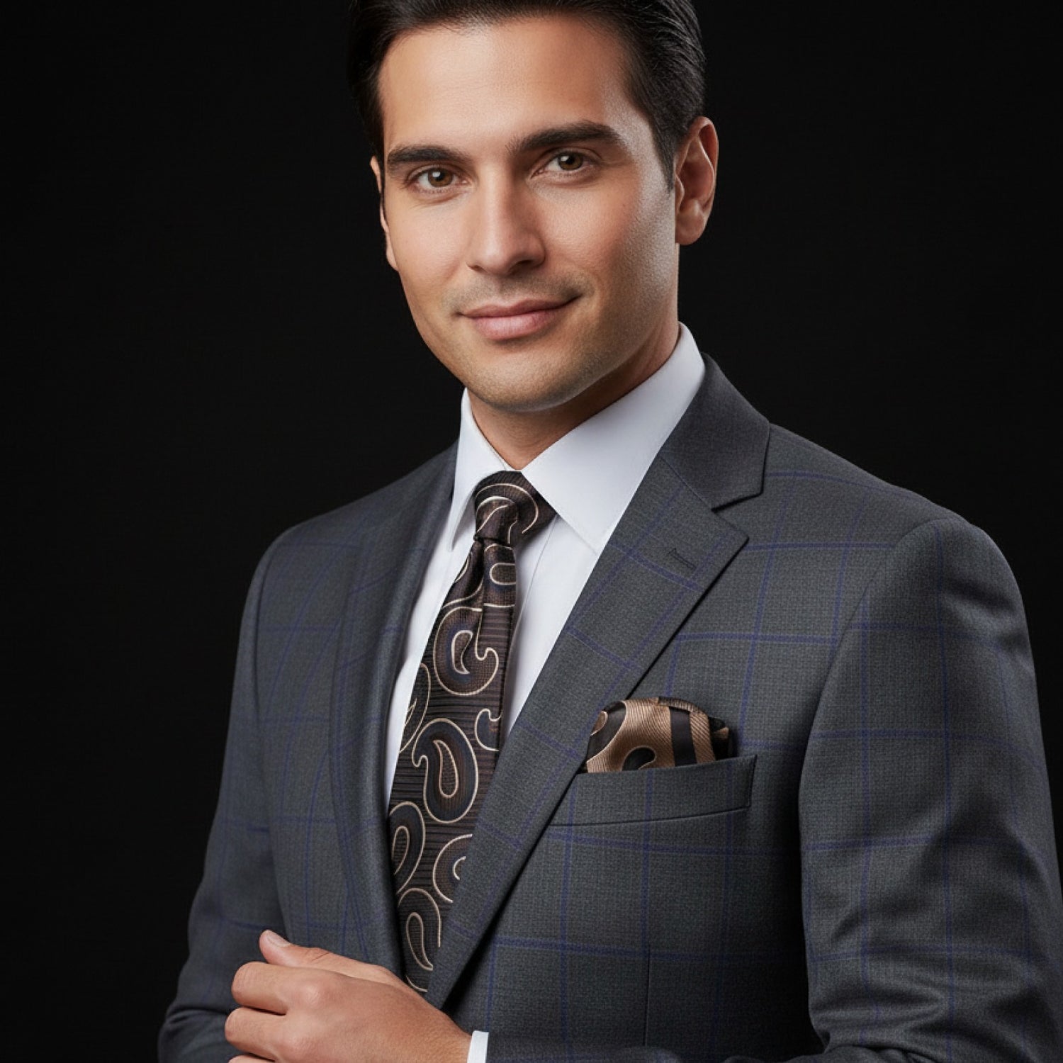 Man wearing a gray suit with a patterned tie and pocket square on a black background