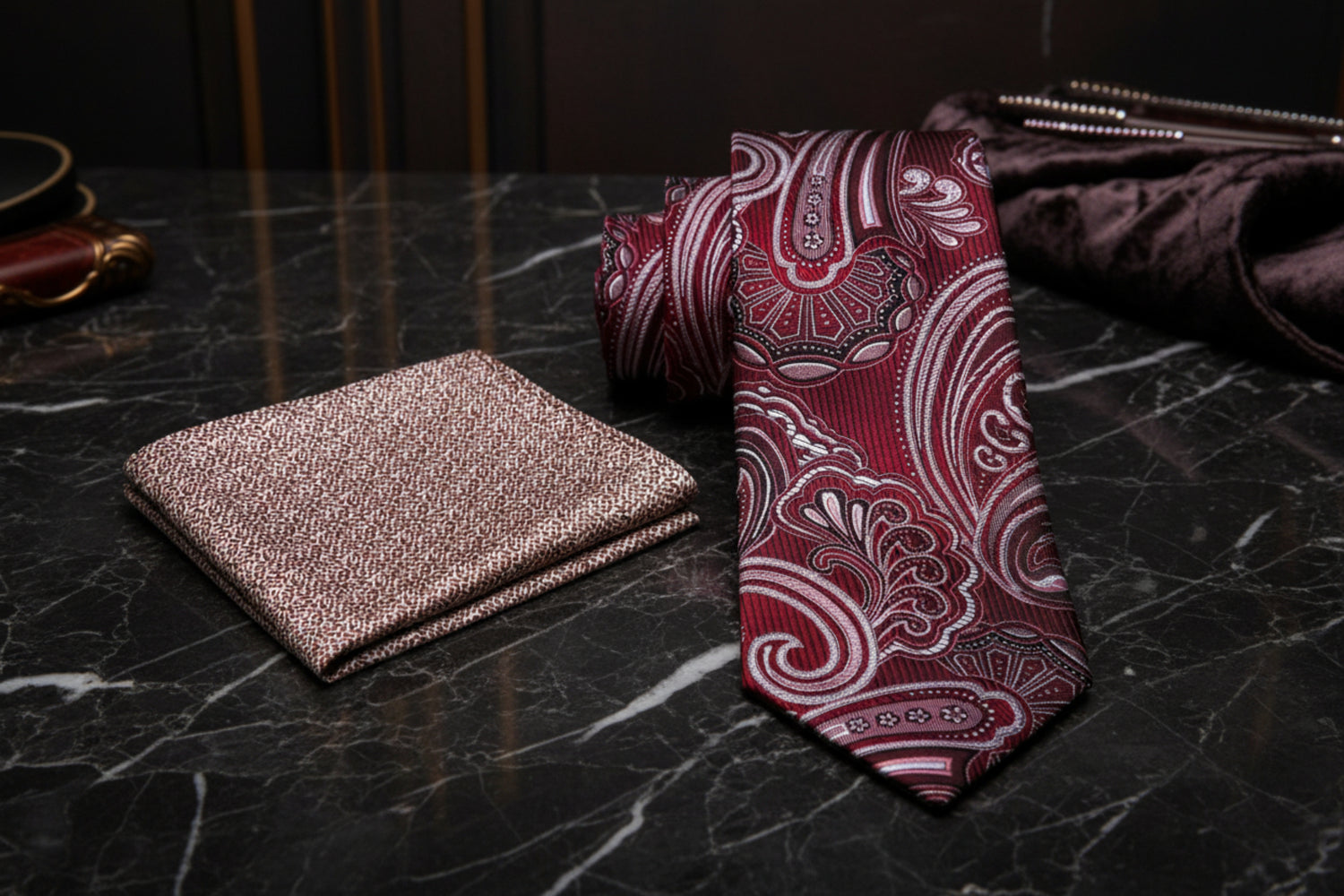 Red paisley tie and accenting pocket square on a white background