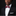 Man wearing a black suit with a white shirt and red bow tie on a dark background