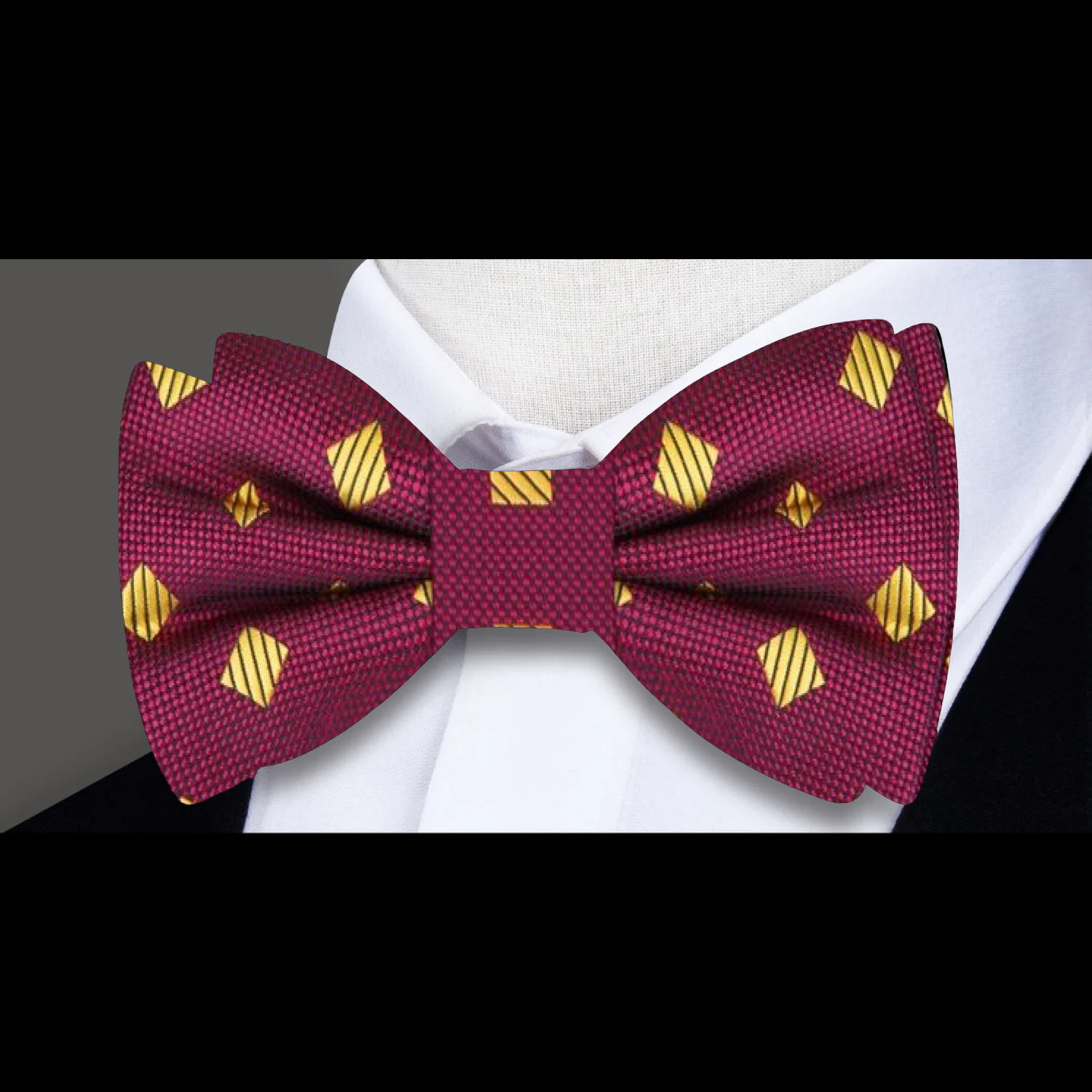 Maroon bow tie with gold diamond pattern on a white shirt