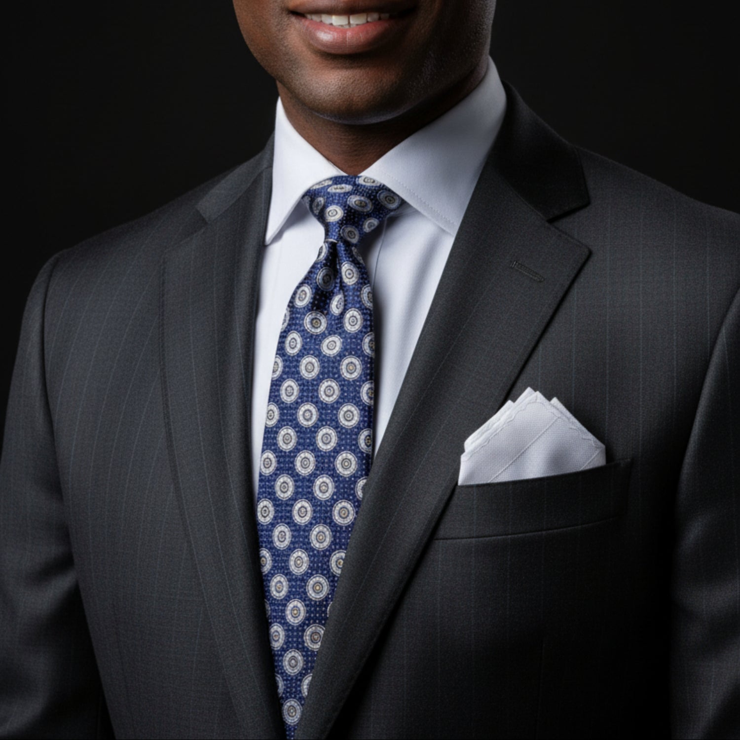 Navy tie with white circular pattern and matching pocket square on a white background