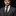 Man wearing a gray suit with a black and brown striped tie against a black background
