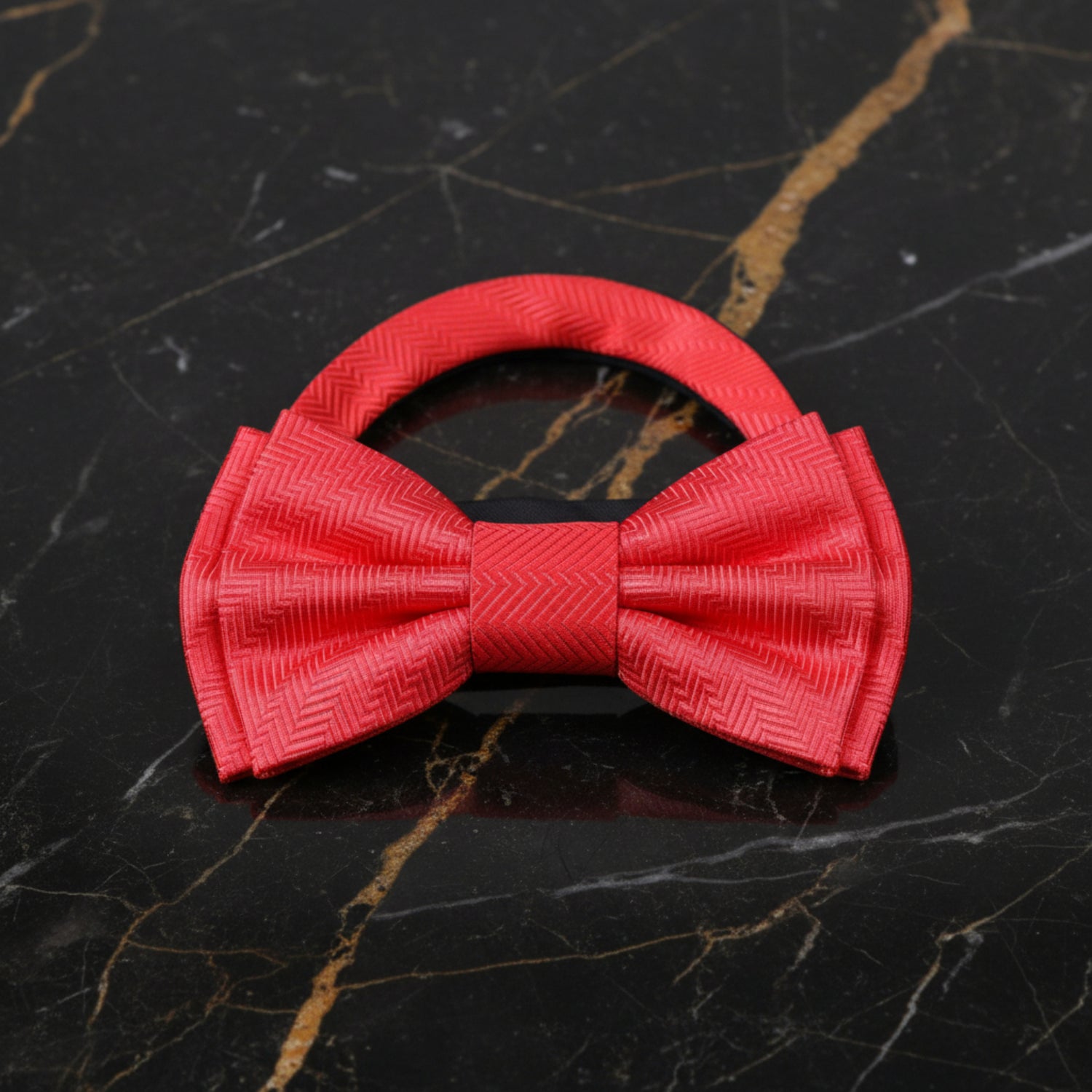 Red bow tie on a black marble surface