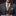 Man wearing a gray suit with an orange paisley tie and pocket square.