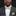 Man wearing a dark suit with a colorful bow tie and pocket square against a black background