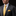 Man wearing a gray suit with a yellow tie and pocket square on a black background