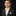 Young boy in a suit with a yellow bow tie against a black background