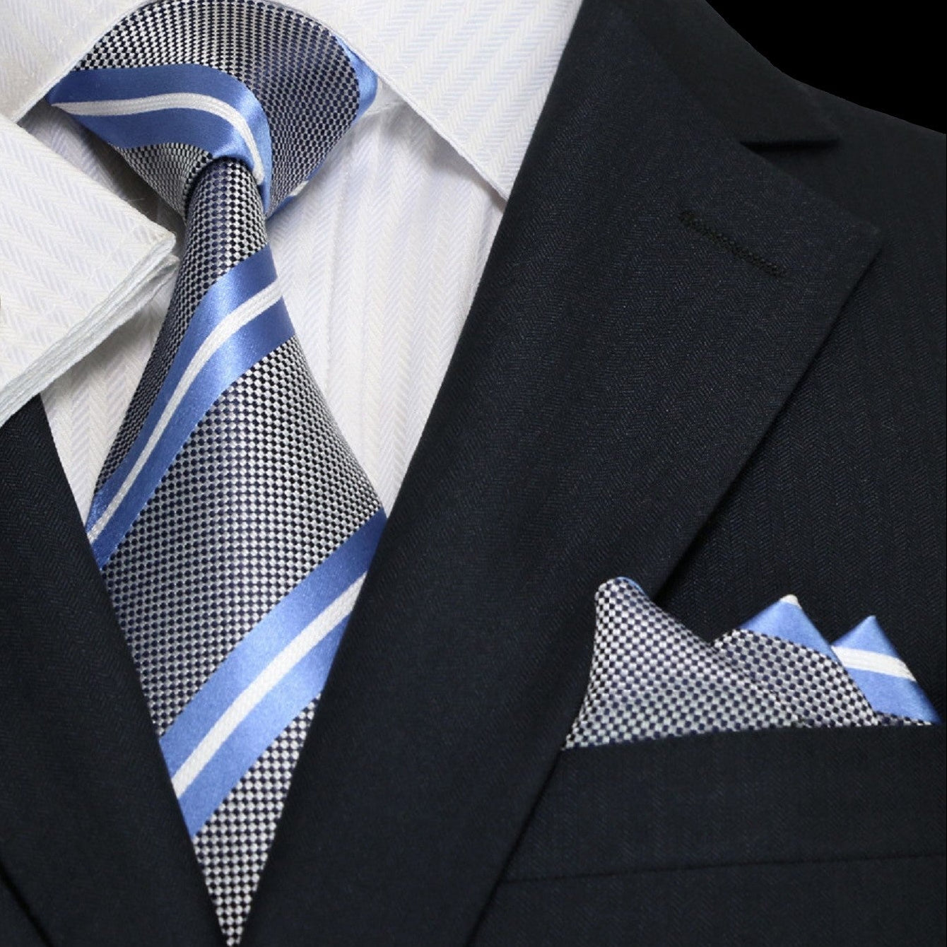Black suit with white shirt, blue striped tie, and matching pocket square.