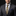 Man wearing a gray suit with a gold and blue patterned tie and pocket square on a black background