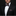 Man wearing a black suit with a patterned bow tie and pocket square on a dark background