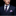 Man wearing a navy suit with a patterned tie and pocket square against a black background