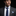 Man wearing a gray suit with a blue tie and pocket square on a black background