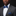 Man wearing a gray suit with a blue bow tie and pocket square against a black background