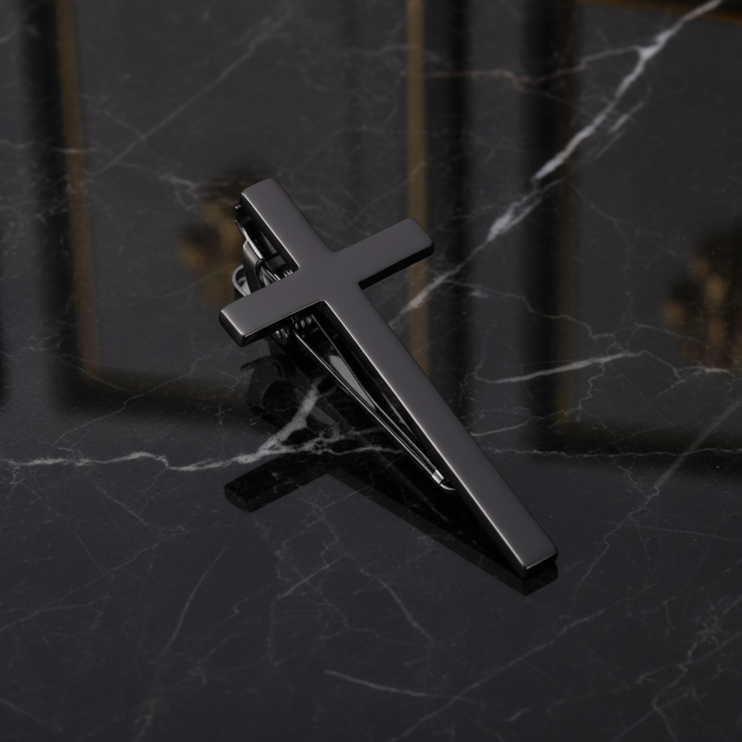 Metallic cross-shaped tie clip on a dark background