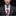 Man wearing a gray suit with a floral tie and pocket square on a black background