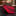 Red and black striped tie on a marble surface with blurred shelves in the background