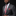 Man wearing a gray suit with a colorful paisley tie and pocket square on a black background