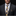 Man wearing a dark suit with a patterned tie and pocket square against a black background