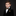 Young boy in a formal black suit with a patterned bow tie and pocket square on a dark background
