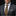 Man wearing a gray suit with a patterned tie and pocket square on a black background