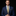 Man wearing a blue suit with a gold tie against a black background