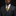 Man wearing a gray suit with a gold tie against a black background
