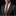 Man wearing a dark suit with a patterned tie and pocket square on a black background